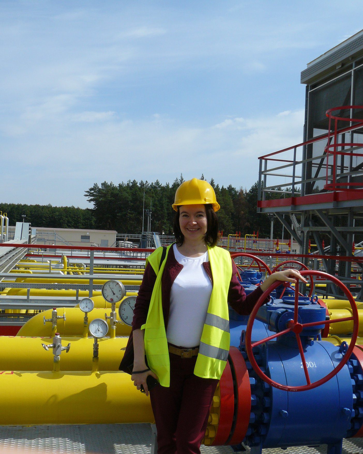 Woman standing in front of an oil and gas refinery
