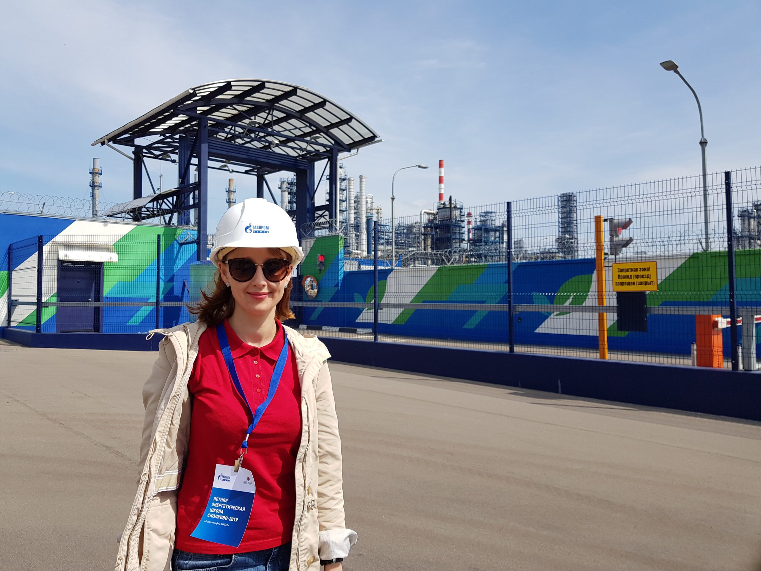 Woman stands in front of factory plant