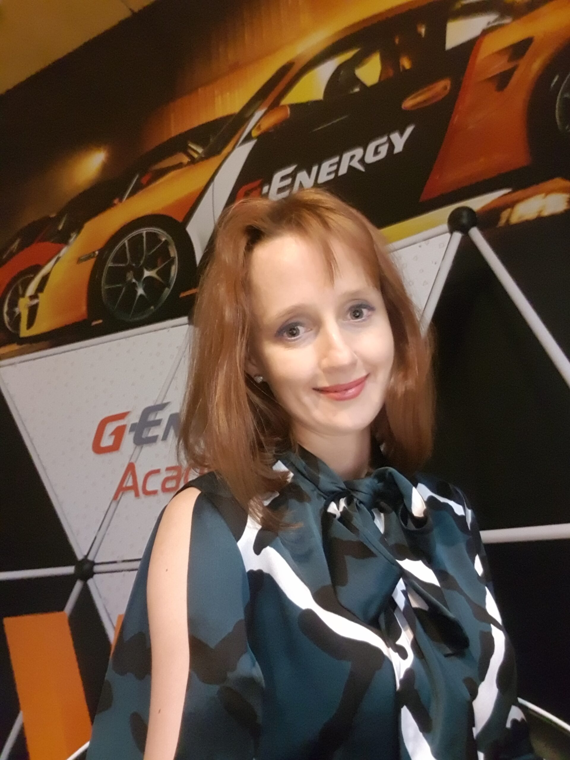 Woman stands in front of photo of car with company branding